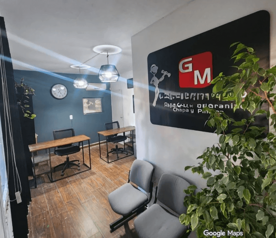 Recepción de Taller GM con escritorios, sillas de espera y el cartel del taller
